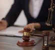 A lawyer discussing a legal document on a desk with a gavel and scales