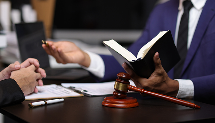 A picture of a courtroom with an attorney holding a book.