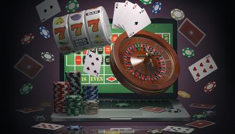 An open laptop with online roulette, slot, and poker symbols spread around